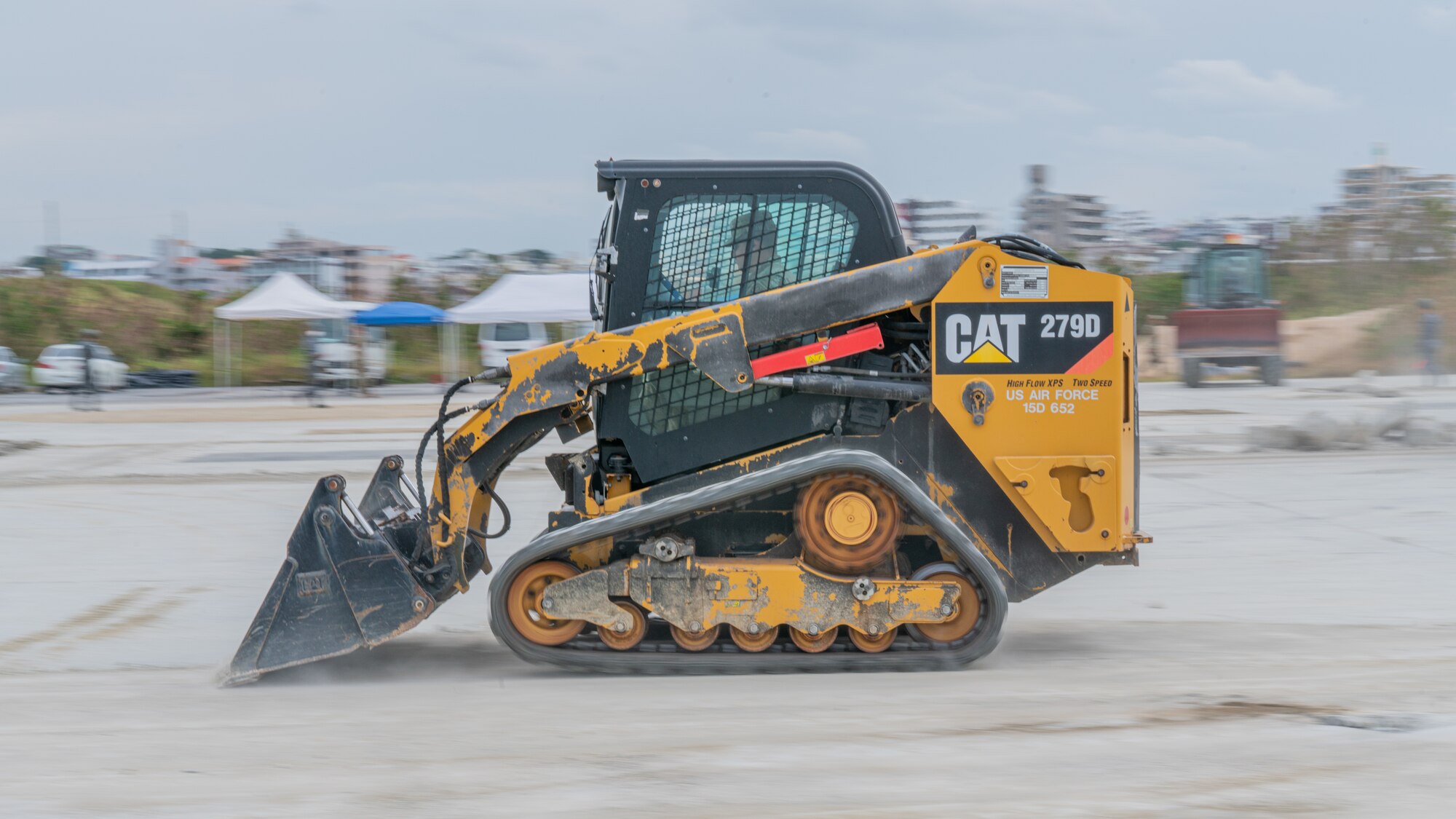 An Airman operates a compact track loader.