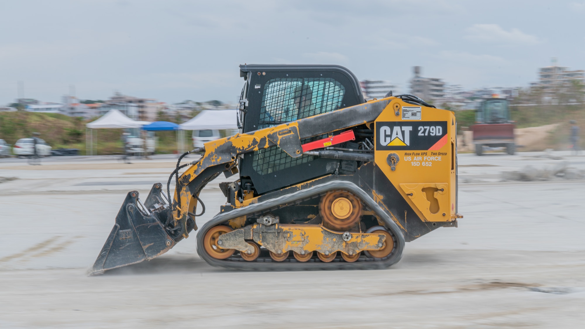 An Airman operates a compact track loader.