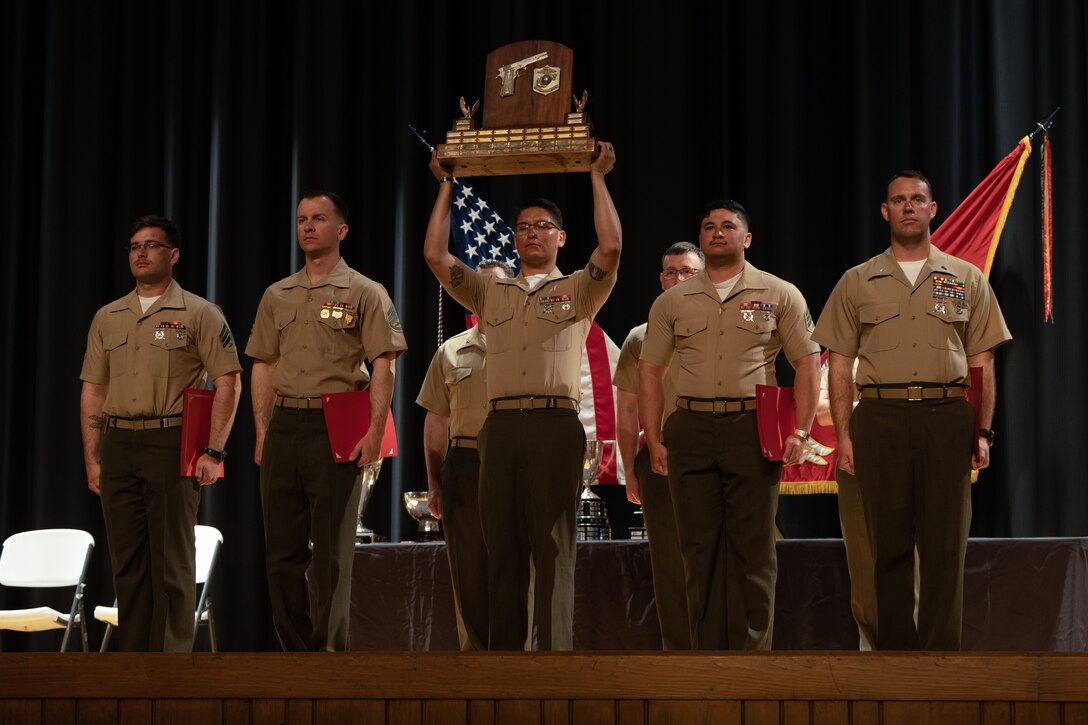 U.S. Marines with Marine Corps Security Forces Training Company Team 1 are awarded the trophy for the pistol team match at the 2023 Marine Corps Marksmanship Competition East Ceremony at the Base Theater on Marine Corps Base Camp Lejeune, North Carolina, March 17, 2023.  The team earned a total of 400 points during the team pistol match during this year’s competition.  (U.S. Marine Corps photo by Cpl. Zeta Johnson)