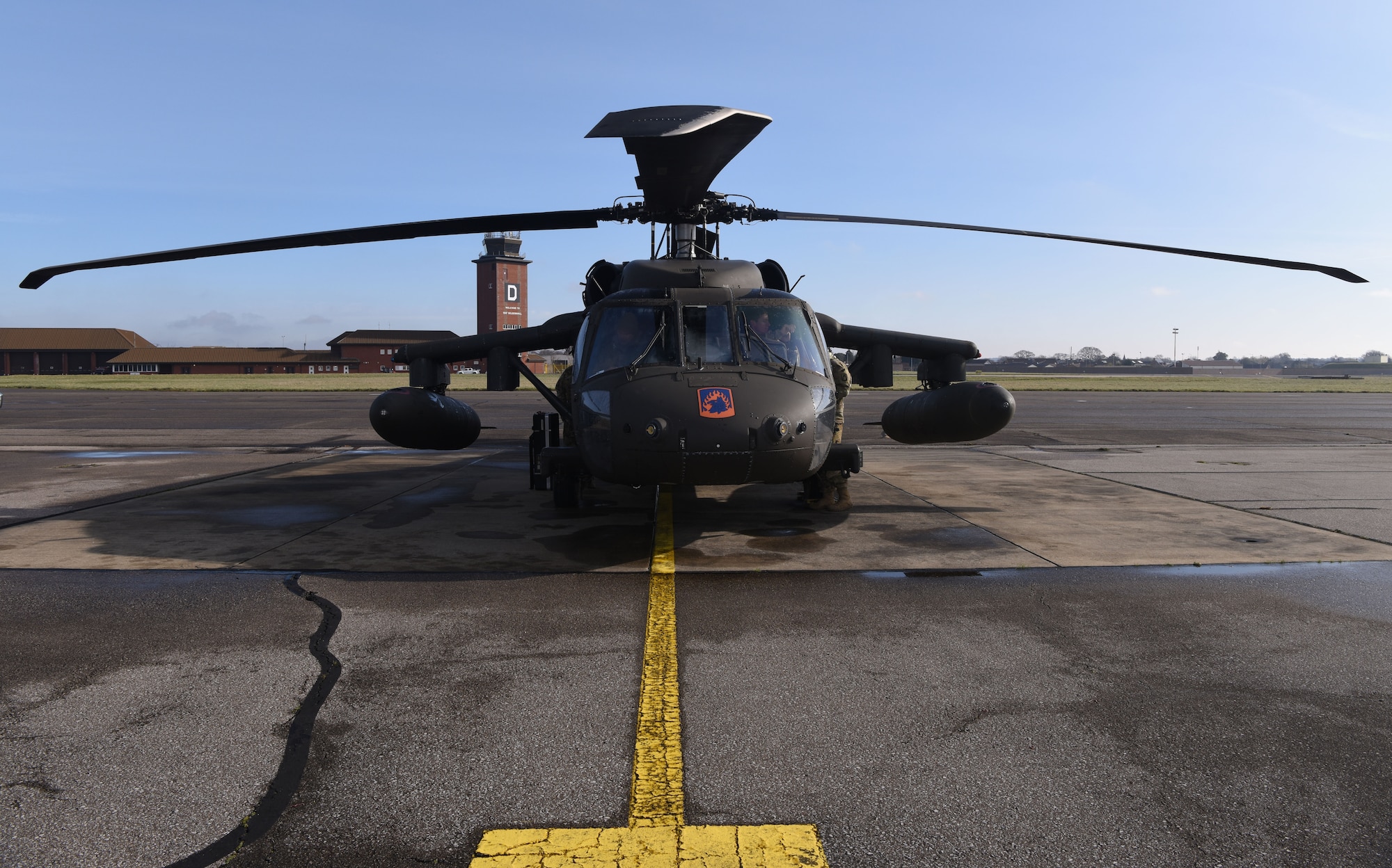 A U.S. Army UH-60M Black Hawk from the 1st Battalion, 214th Aviation Regiment (General Support Aviation Battalion), Weisbaden, Germany, sits on the flightline as its maintainers and aircrew prep it for takeoff at Royal Air Force Mildenhall, England, March 15, 2023. The helicopters stopped off for refueling and rest before heading to RAF Leeming, Scotland. (U.S. Air Force photo by Karen Abeyasekere)