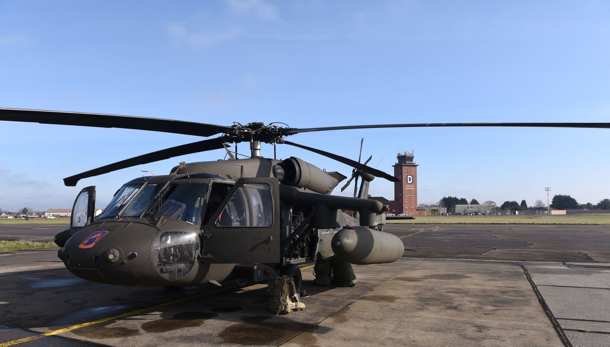 A U.S. Army UH-60M Black Hawk from the 1st Battalion, 214th Aviation Regiment (General Support Aviation Battalion), Weisbaden, Germany, sits on the flightline as its maintainers and aircrew prep it for takeoff at Royal Air Force Mildenhall, England, March 15, 2023. The helicopters stopped off for refueling and rest before heading to RAF Leeming, Scotland. (U.S. Air Force photo by Karen Abeyasekere)