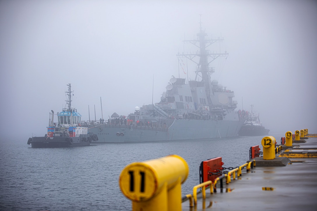 A ship arrives at a port in foggy conditions.