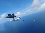 Four Naval aircraft flying in the sky