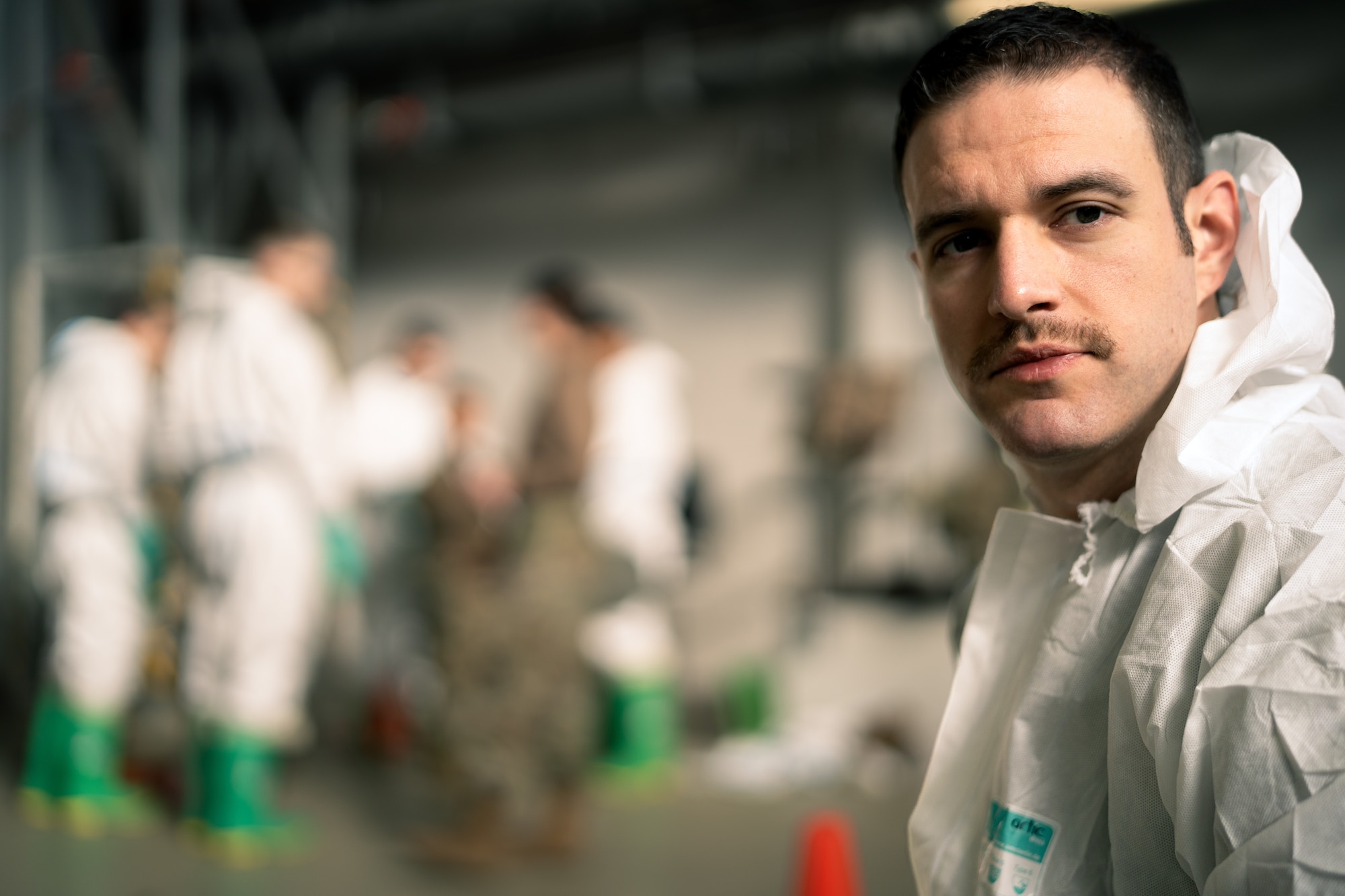 U.S. Air Force Master Sgt. Christopher Chamberlin, 86th Aircraft Maintenance Squadron aircraft maintenance unit superintendent, puts on protective gear during exercise Radiant Falcon at Ramstein Air Base, Germany, March 16, 2023.