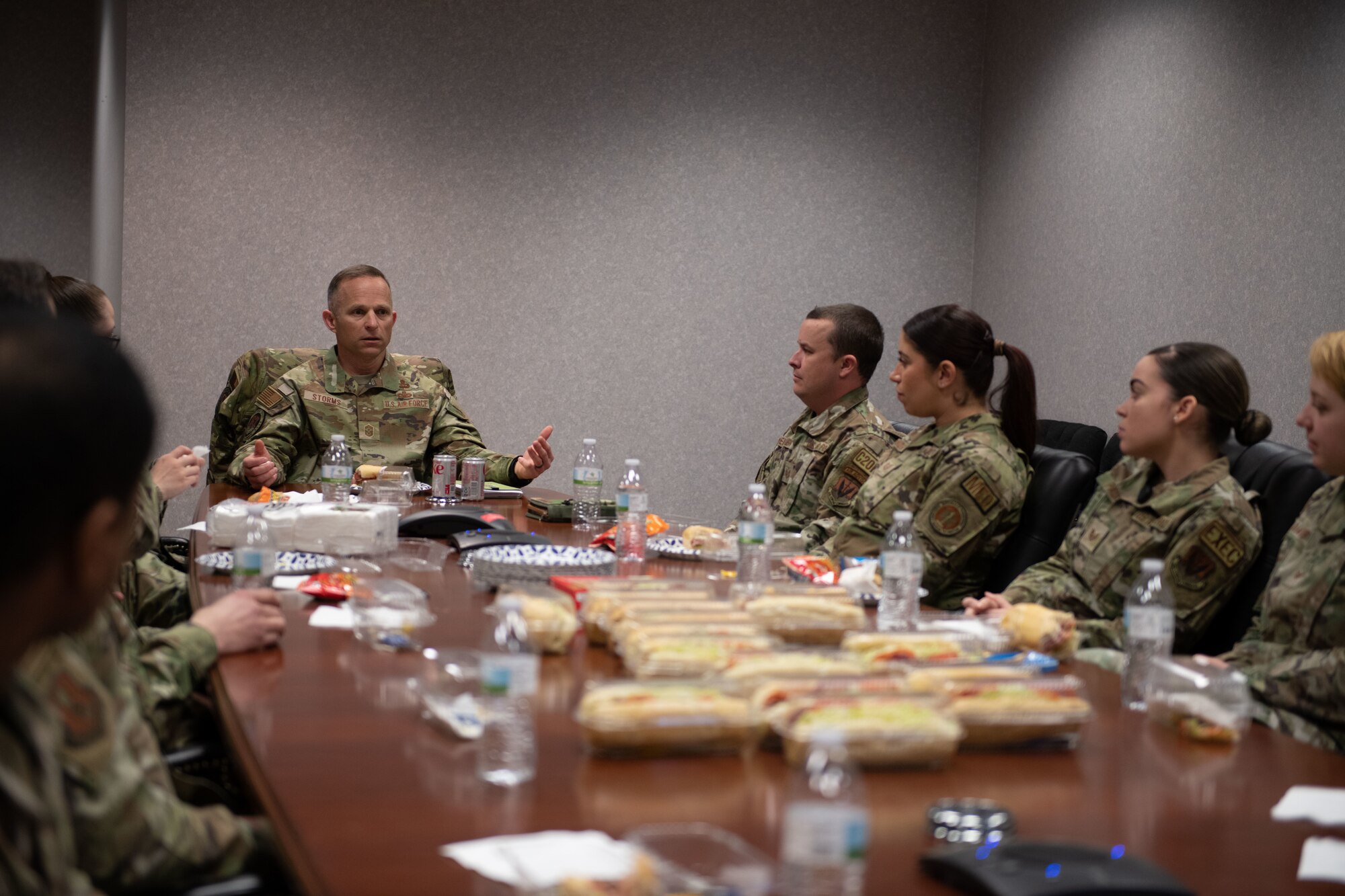 Airmen eat food at conference room.