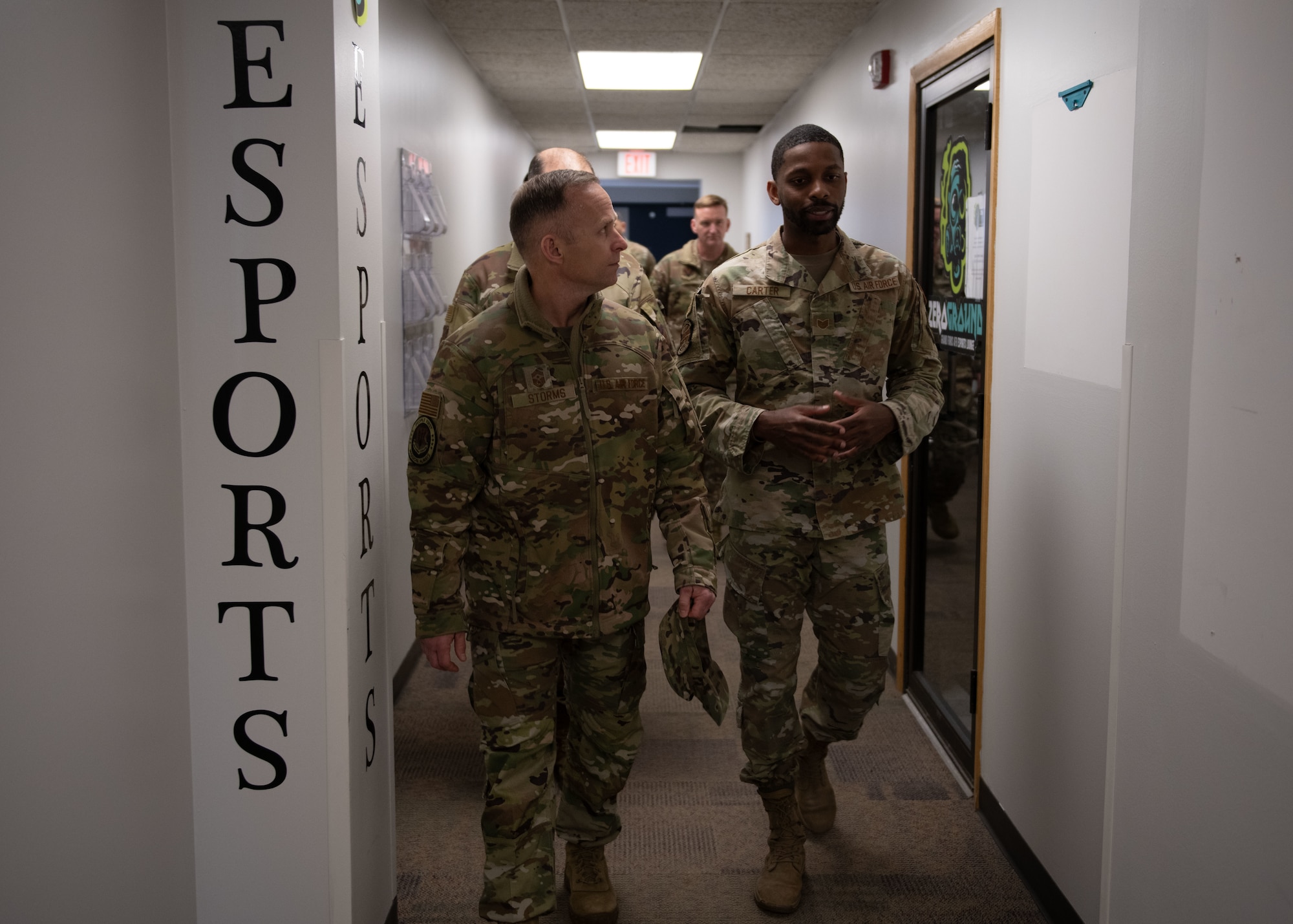 Airmen walk through hallway.
