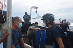 Coast Guard Auxiliarist Hua Lin McCaffrey completes a boarding at sea in the Indo-Pacific, May 2, 2022. Volunteers with interpreting skills like McCaffrey are in high demand in the Coast Guard Auxiliary, to help the Coast Guard detect and deter illegal, unreported and unregulated fishing. (U.S. Coast Guard photo by Petty Officer 1st Class Nate Littlejohn)