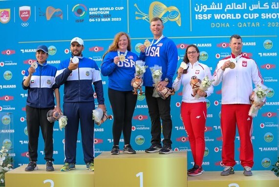 Man and woman in U.S.A. uniform with medals standing on winner's podium.