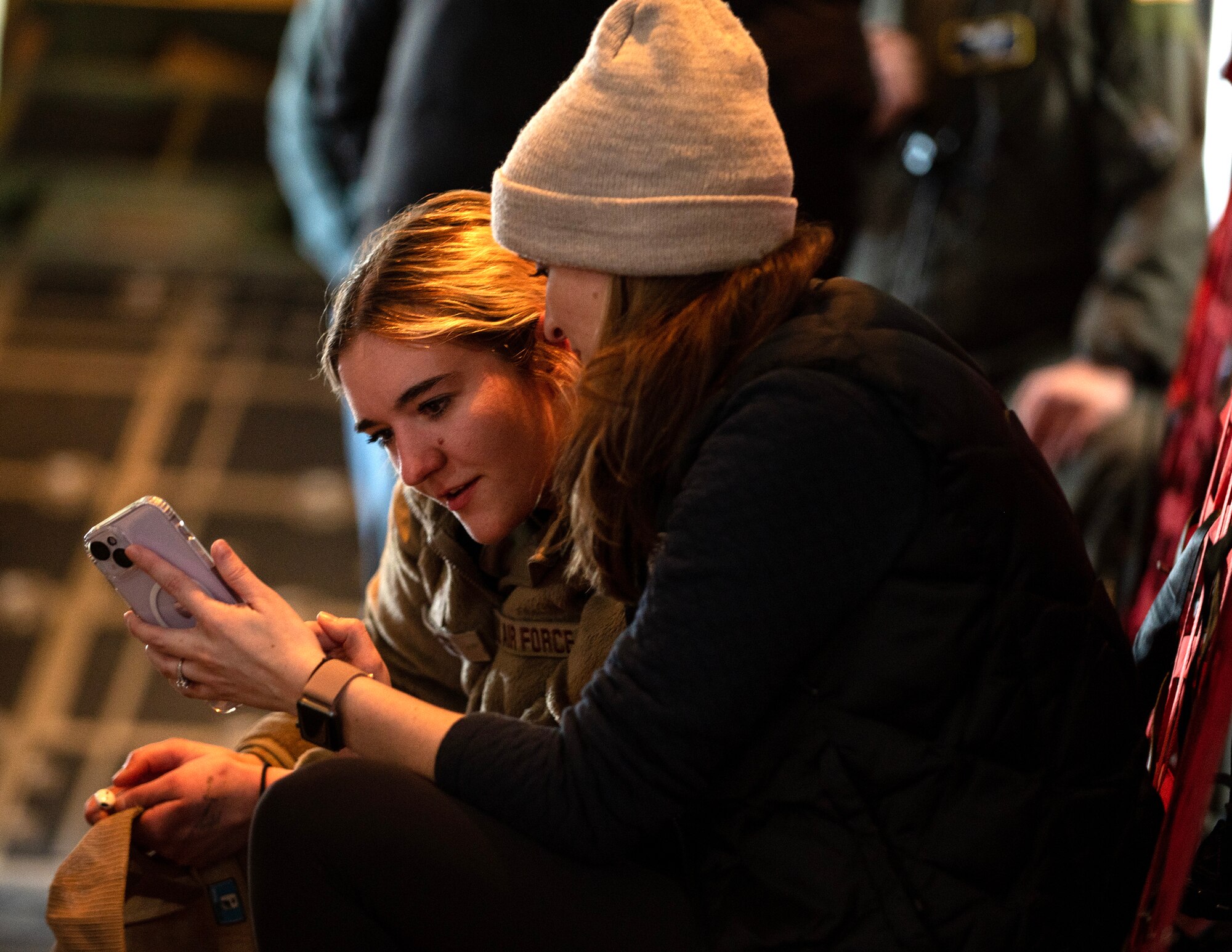 Melissa Loomer, right, shows something from her phone with U.S. Air Force Airman 1st Class Ashley Boros, 133rd Maintenance Group, over the skies of Minnesota, Minn., March 12, 2023.