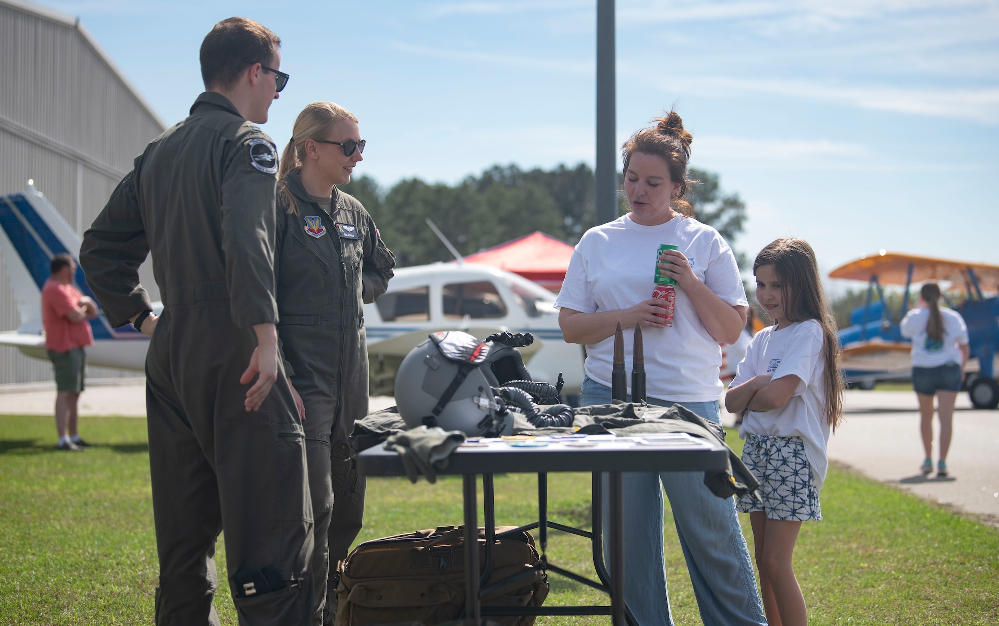 U.S. Air Force Capt. Rose Porras, 71st Rescue Squadron HC-130J Combat King II pilot, and Capt. Nicholas Porras, 75th Fighter Squadron A-10 Thunderbolt II pilot, show flight equipment to a mother and daughter during the Youth Flight Experience event at Fitzgerald, Georgia, March 4, 2023. This was the second year members of Moody Air Force Base participated in the event. (U.S. Air Force photo by Staff Sgt. Thomas Johns)