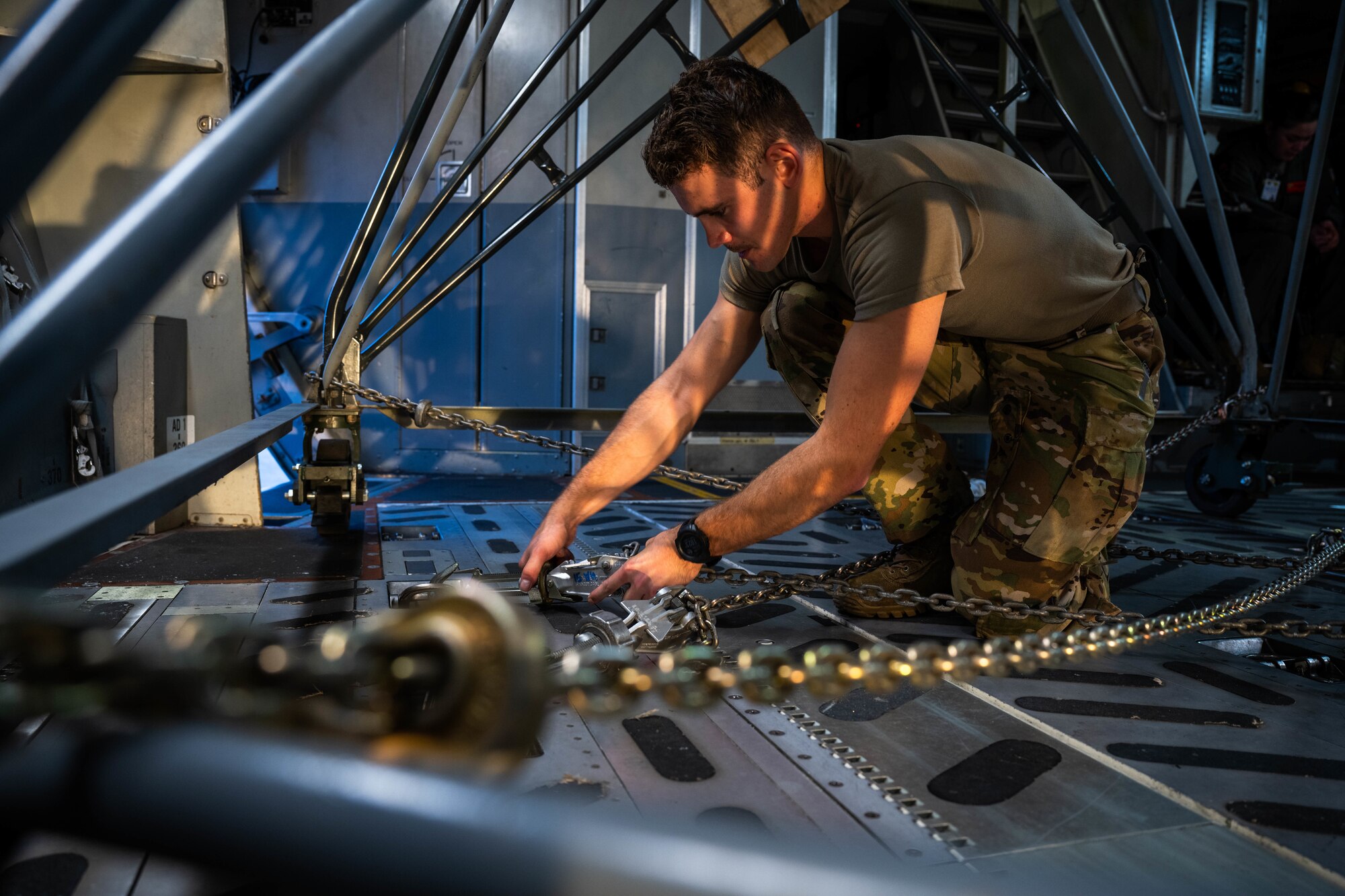 Airman 1st Class Jace Grayson, 535th Airlift Squadron loadmaster, secures cargo on a C-17 Globemaster III  at Joint Base Pearl Harbor-Hickam, Hawaii, during the Joint Base Readiness Exercise, March 1, 2023. The 15th Wing trains to operate, fight and advance its capabilities through realistic training exercises designed to test and develop joint logistics, resilience and rapid strategic mobility. (U.S. Air Force photo by Senior Airman Makensie Cooper)