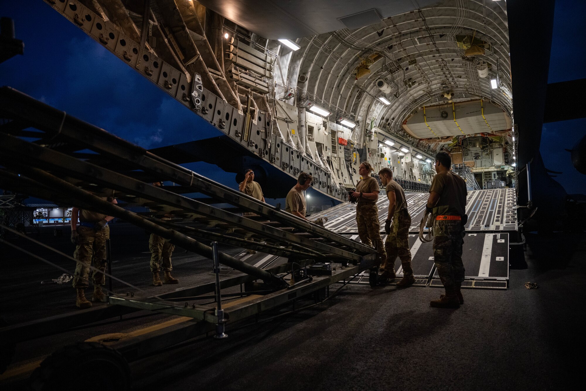 Airmen assigned to the 535th Airlift Squadron and the 735th Air Mobility Squadron load cargo on a C-17 Globemaster III at Joint Base Pearl Harbor-Hickam, Hawaii, during the Joint Base Readiness Exercise, March 1, 2023. JBRE provides realistic training in various operations, enabling our Airmen to provide distinct tools and capabilities needed for mission success in an ever-changing theater. (U.S. Air Force photo by Senior Airman Makensie Cooper)