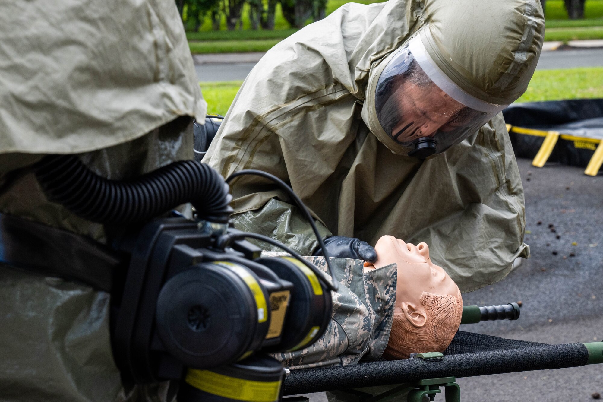 Airmen assigned to the 15th Medical Group decontamination team triage a simulated patient during a contamination drill at Joint Base Pearl Harbor-Hickam, Hawaii, March 2, 2023. This course trained 22 personnel on how to set up and tear down the decontamination tent to start treating patients. (U.S. Air Force photo by Senior Airman Makensie Cooper)