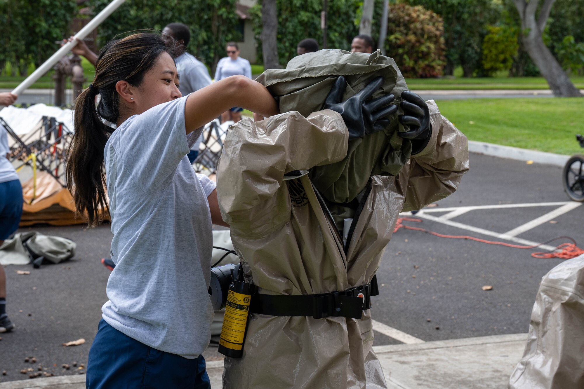 Airmen assigned to the 15th Medical Group put on their personal protective equipment during an exercise at Joint Base Pearl Harbor-Hickam, Hawaii, March 2, 2023. This training teaches and refreshes 15th MDG medical personnel DECON procedures to help protect the military treatment facility and personnel from further contamination. (U.S. Air Force photo by Senior Airman Makensie Cooper)