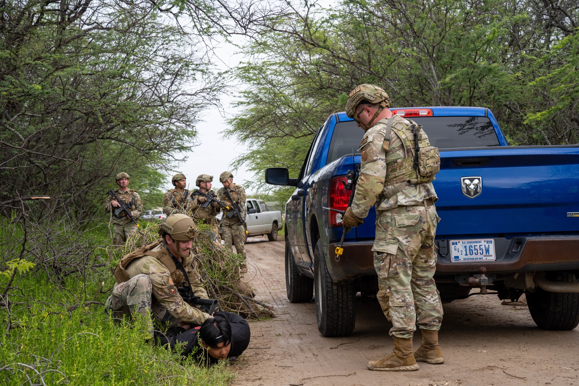 Members of the 647th Security Forces Squadron detain an individual  simulating a perimeter breach during Joint Base Readiness Exercise 23-01 at Joint Base Pearl Harbor-Hickam, Hawaii, March 7, 2023. The 15th Wing’s ability to surge combat-ready forces across the theater is critical to supporting regional alliances, partnerships and stability. (U.S. Air Force photo by SrA Makensie Cooper)