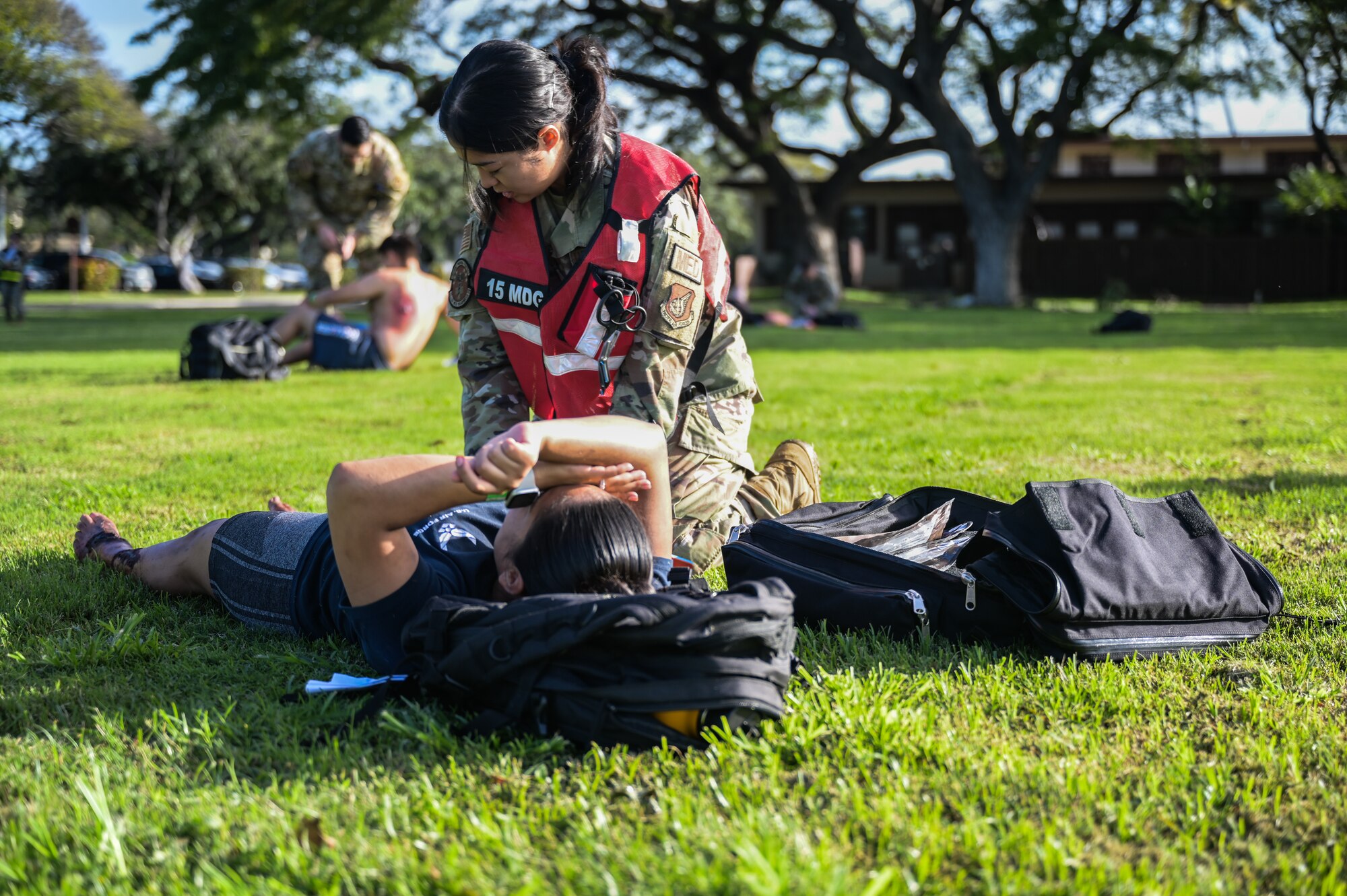 Senior Airman Hyesung Lee, 15th Operational Medical Readiness Squadron flight and operational medical technician, provides first aid to a volunteer with simulated injuries during a Joint Base Readiness Exercise at Joint Base Pearl Harbor-Hickam, Hawaii, Mar. 8, 2023. The 15th Wing trains to operate, fight and advance its capabilities through realistic training exercises designed to test and develop joint logistics, resilience and rapid strategic mobility. (U.S. Air Force photo by Staff Sgt. Alan Ricker)