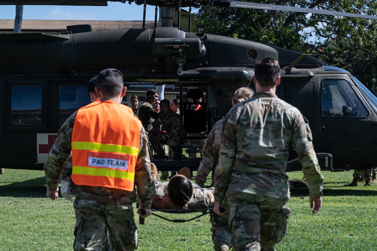Airmen assigned to the 15th Medical Group and soldiers from the 25th Combat Aviation Brigade practice patient litter carries to and from a HH-60 Black Hawk during a Joint Base Readiness Exercise at Joint Base Pearl Harbor-Hickam, Hawaii, Mar. 8, 2023. The 15th Wing trains to operate, fight and advance its capabilities through realistic training exercises designed to test and develop joint logistics, resilience and rapid strategic mobility. (U.S. Air Force photo by Staff Sgt. Alan Ricker)