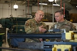 Master Sgt. Juan Gonzalez, 433rd Maintenance Group aircraft structural maintenance, speaks to Brig. Gen. Max Stitzer,  mobilization assistant to Headquarters Air Force Director of Staff, about the capabilities of the computer numerical control machine during Stitzer's visit to the 433rd Airlift Wing Joint Base San Antonio-Lackland, Texas, March 5, 2023.