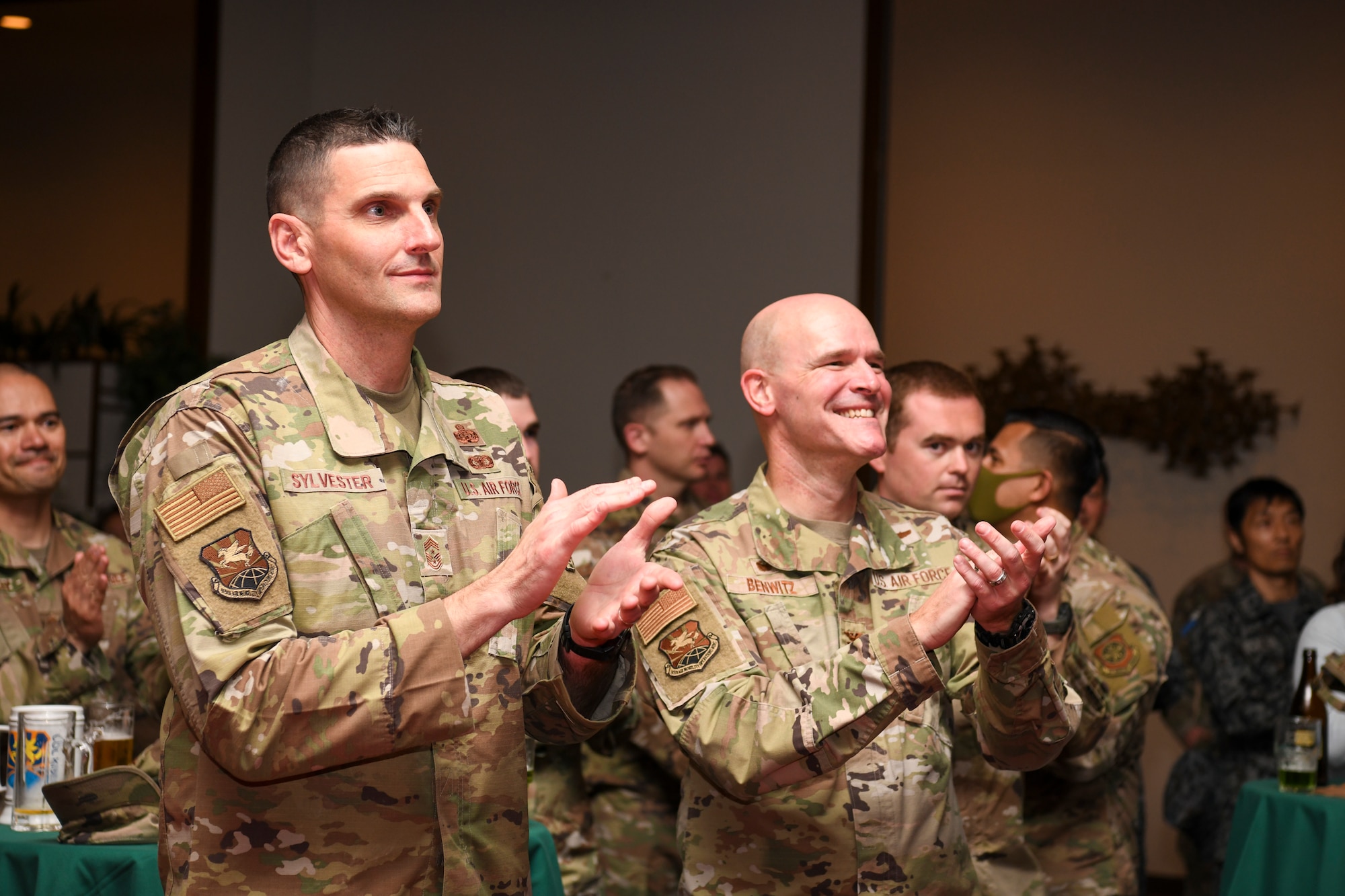 U.S. Air Force Col. Kyle Benwitz, 515th Air Mobility Operations Wing commander, and Chief Master Sgt. Michael Sylvester, 515th AMOW command chief, clap during a senior master sergeant release party at Yokota Air Base, Japan, March 17, 2023. Air Force officials selected 1,629 master sergeants for promotion to senior master sergeant, out of 16,031 eligible, for a selection rate of 10.16 percent in the 23E8 promotion cycle. (U.S. Air Force photo by Senior Airman Spencer Tobler)