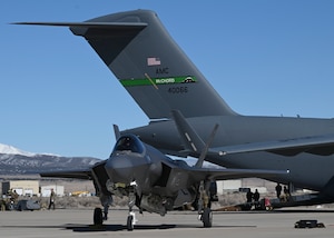 An F-35 Lightning II assigned to the 4th Fighter Squadron, Hill Air Force Base, Utah, parks next to a C-17 Globemaster III, assigned to the 62d Airlift Wing, Joint Base Lewis-McChord, Washington, at Michael Army Airfield, Utah, during Exercise Monster Jam, March 9, 2023. The 7th Airlift Squadron, out of JBLM, conducted the first-ever off-station integrated combat turn with the F-35. (U.S. Air Force photo by Senior Airman Callie Norton)
