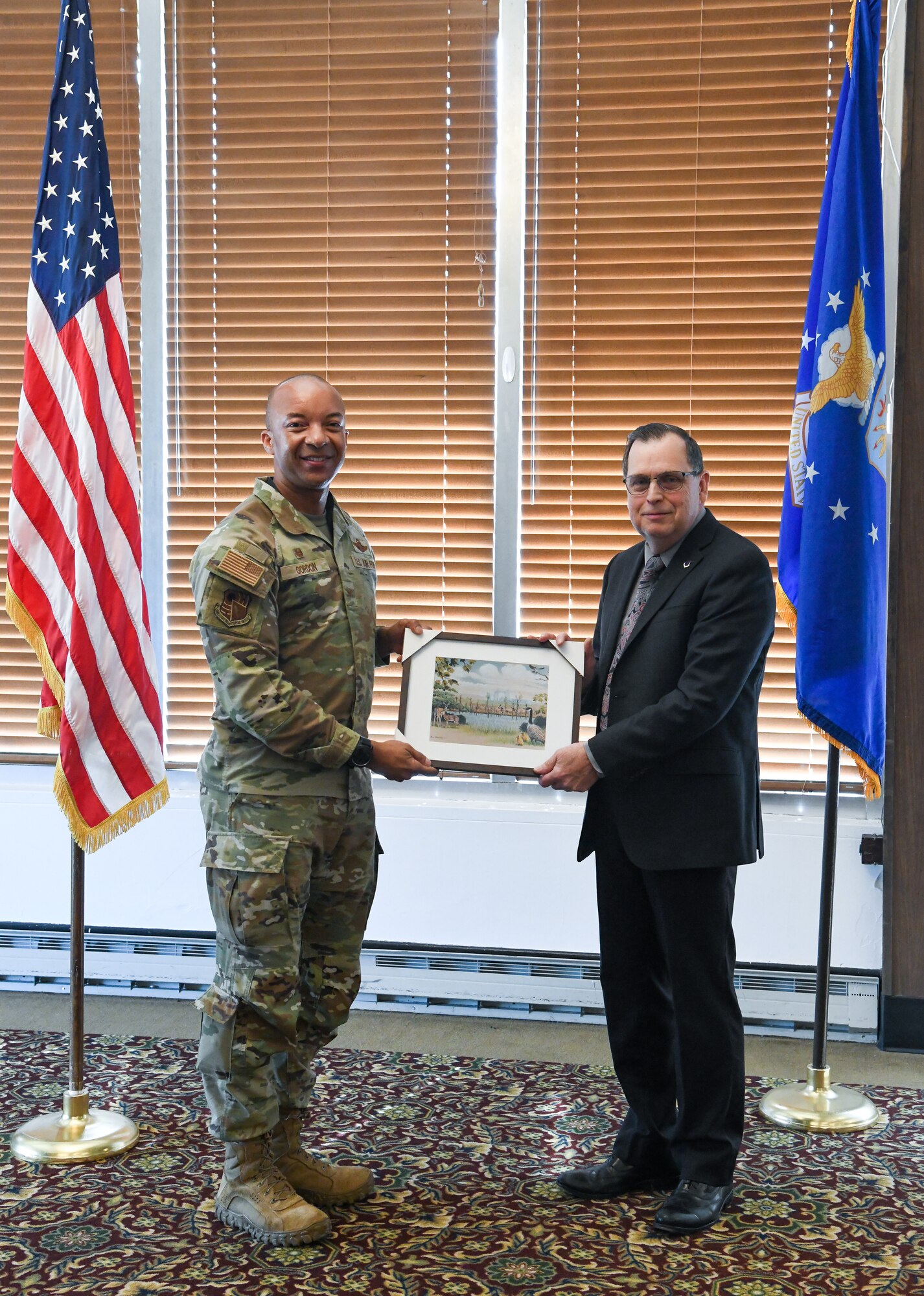 Air Force officer presenting framed print to civilian