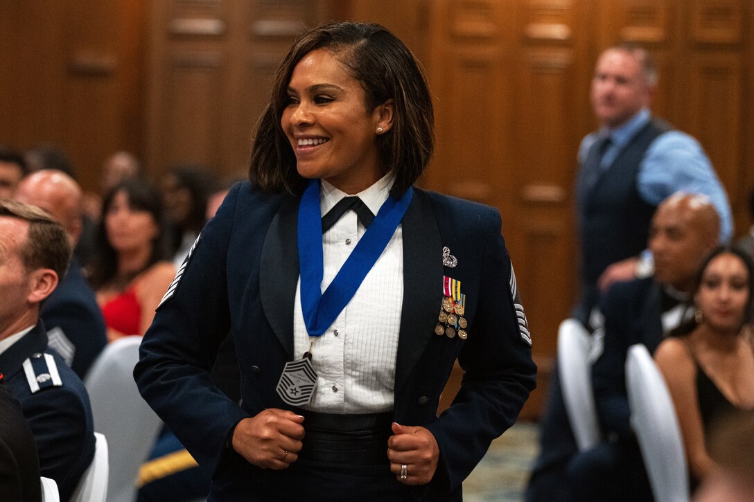 An airman smiles while wearing a medal.