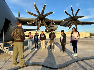 a group of people stand inside a hangar