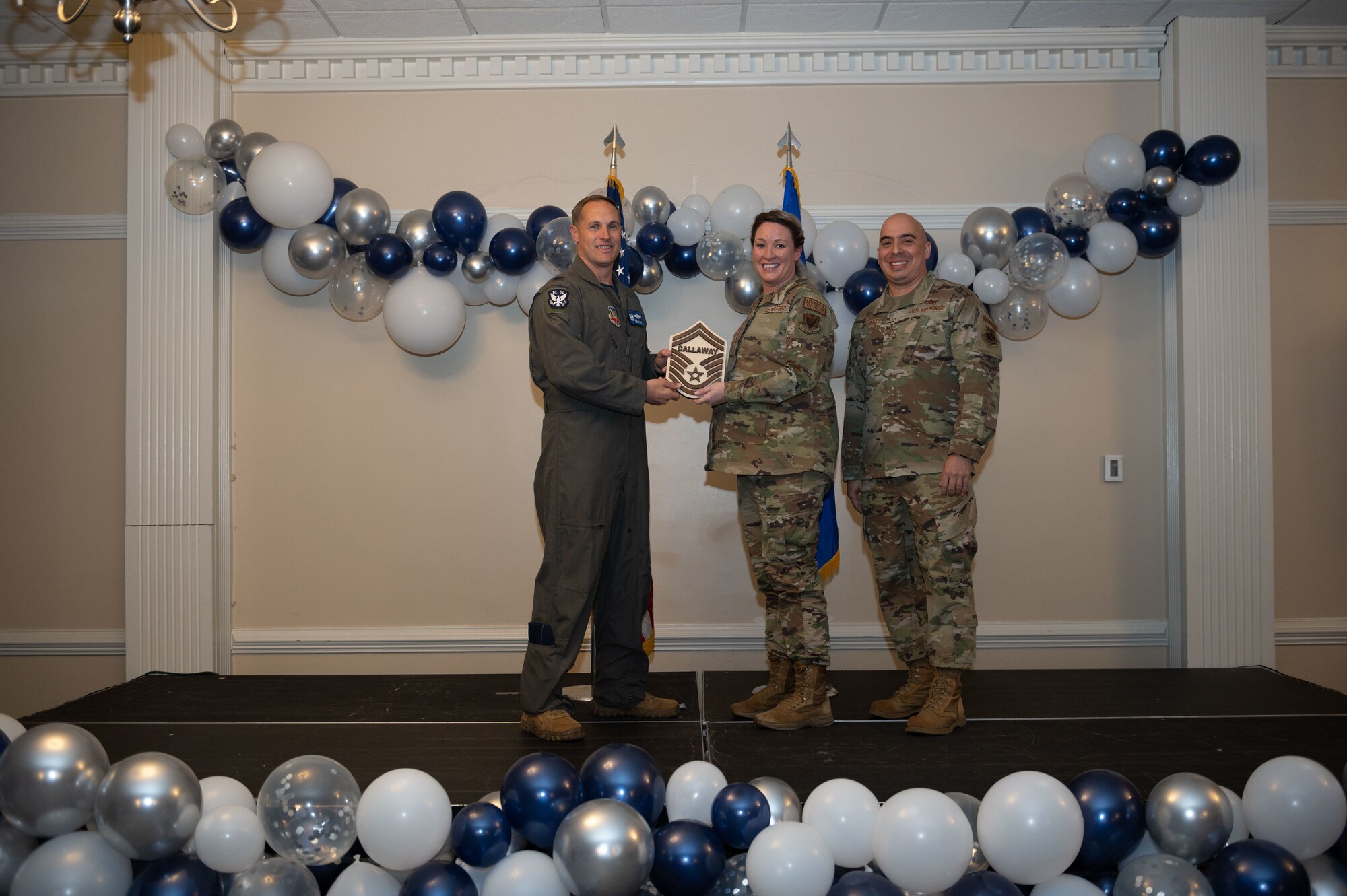 Col. Lucas Teel, 4th Fighter Wing commander, and Chief Master Sgt. Peter Martinez, 4th FW command chief, present a plaque to Senior Master Sgt. select Melissa Callaway, 4th Maintenance Groups maintenance operations superintendent, during the senior master sergeant release ceremony at Seymour Johnson Air Force Base, North Carolina, March 17, 2023. Air Force officials selected 1,629 master sergeants for promotion to senior master sergeant, out of 16,031 eligible, for a selection rate of 10 percent this promotion cycle. (U.S. Air Force photo by Airman 1st Class Rebecca Sirimarco-Lang)