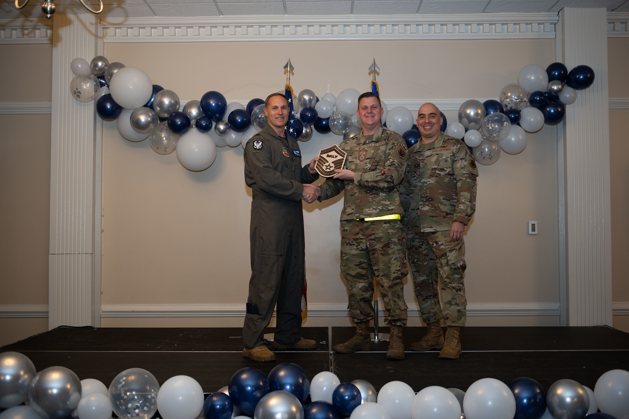Col. Lucas Teel, 4th Fighter Wing commander, and Chief Master Sgt. Peter Martinez, 4th FW command chief, present a plaque to Senior Master Sgt. select Joshua Daly, 336th Fighter Squadron production superintendent, during the senior master sergeant release ceremony at Seymour Johnson Air Force Base, North Carolina, March 17, 2023. The ceremony allowed wing leadership, family and friends to recognize the base’s newest Senior Master Sergeant selects. (U.S. Air Force photo by Airman 1st Class Rebecca Sirimarco-Lang)