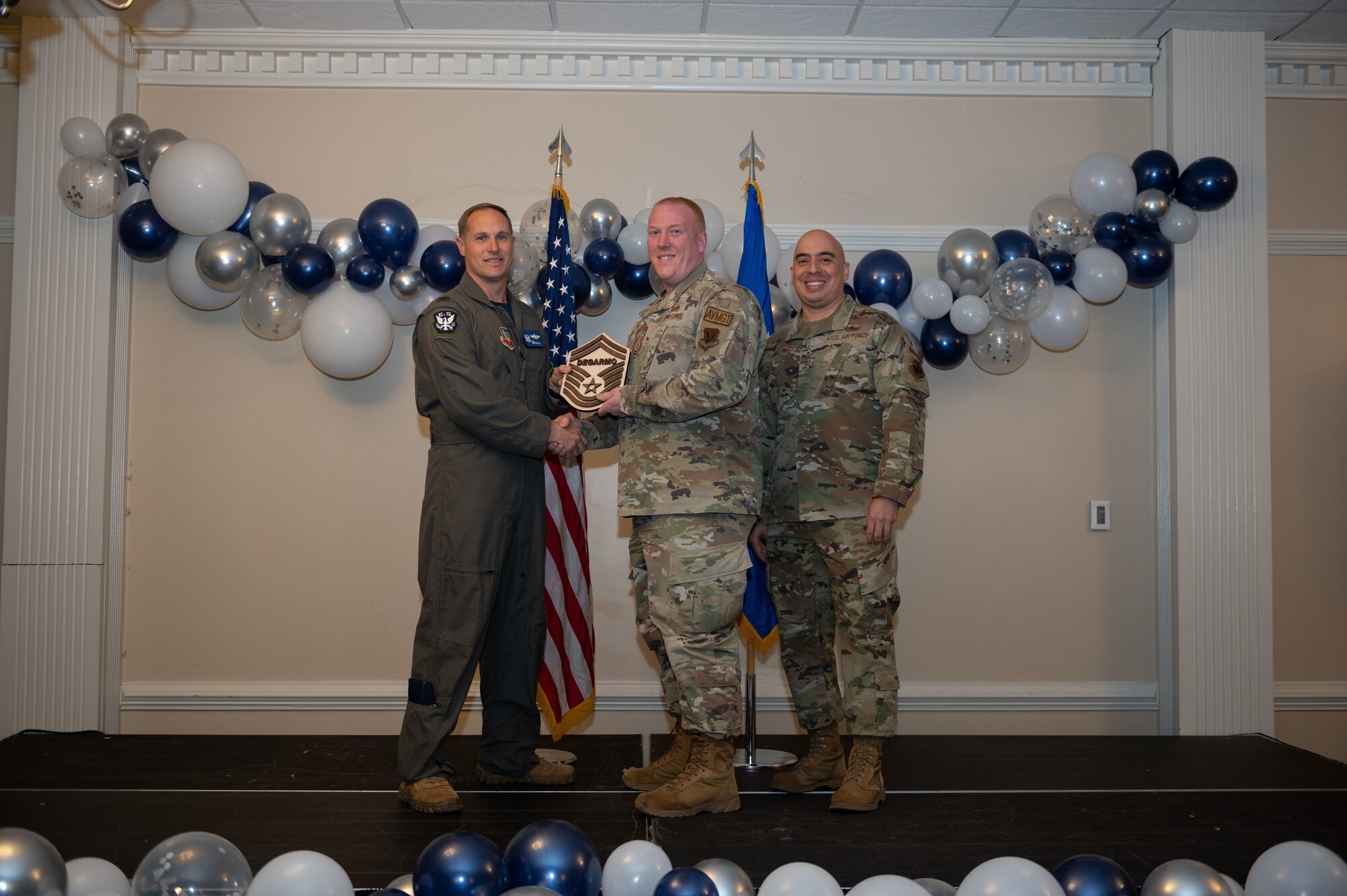 Col. Lucas Teel, 4th Fighter Wing commander, and Chief Master Sgt. Peter Martinez, 4th FW command chief, present a plaque to Senior Master Sgt. select Donald Degarmo, 4th Operations Support Squadron superintendent host aviation resource management, during the senior master sergeant release ceremony at Seymour Johnson Air Force Base, North Carolina, March 17, 2023. Air Force officials selected 1,629 master sergeants for promotion to senior master sergeant, out of 16,031 eligible, for a selection rate of 10 percent this promotion cycle. (U.S. Air Force photo by Airman 1st Class Rebecca Sirimarco-Lang)
