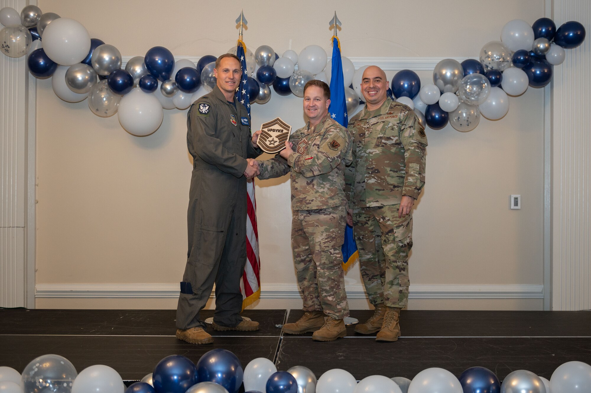 Col. Lucas Teel, 4th Fighter Wing commander, and Chief Master Sgt. Peter Martinez, 4th FW command chief, present a plaque to Senior Master Sgt. select Jeffery Updyke, 4th Civil Engineer Squadron non-commissioned officer in charge, during the senior master sergeant release ceremony at Seymour Johnson Air Force Base, North Carolina, March 17, 2023. The ceremony allowed wing leadership, family and friends to recognize the base’s newest Senior Master Sergeant selects. (U.S. Air Force photo by Airman 1st Class Rebecca Sirimarco-Lang)