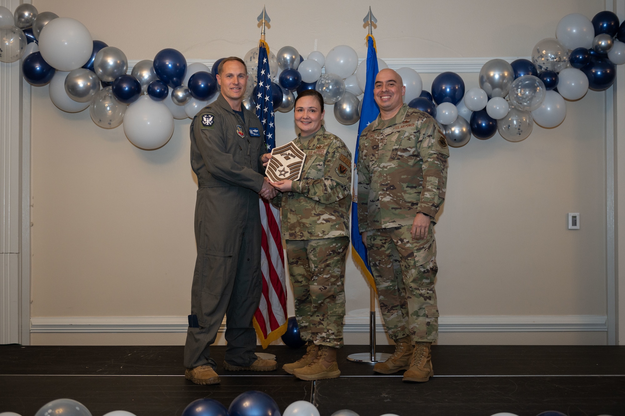 Col. Lucas Teel, 4th Fighter Wing commander, and Chief Master Sgt. Peter Martinez, 4th FW command chief, present a plaque to Senior Master Sgt. select Suge Wilson, 4th Logistics Readiness Squadron first sergeant, during the senior master sergeant release ceremony at Seymour Johnson Air Force Base, North Carolina, March 17, 2023. Air Force officials selected 1,629 master sergeants for promotion to senior master sergeant, out of 16,031 eligible, for a selection rate of 10 percent this promotion cycle. (U.S. Air Force photo by Airman 1st Class Rebecca Sirimarco-Lang)