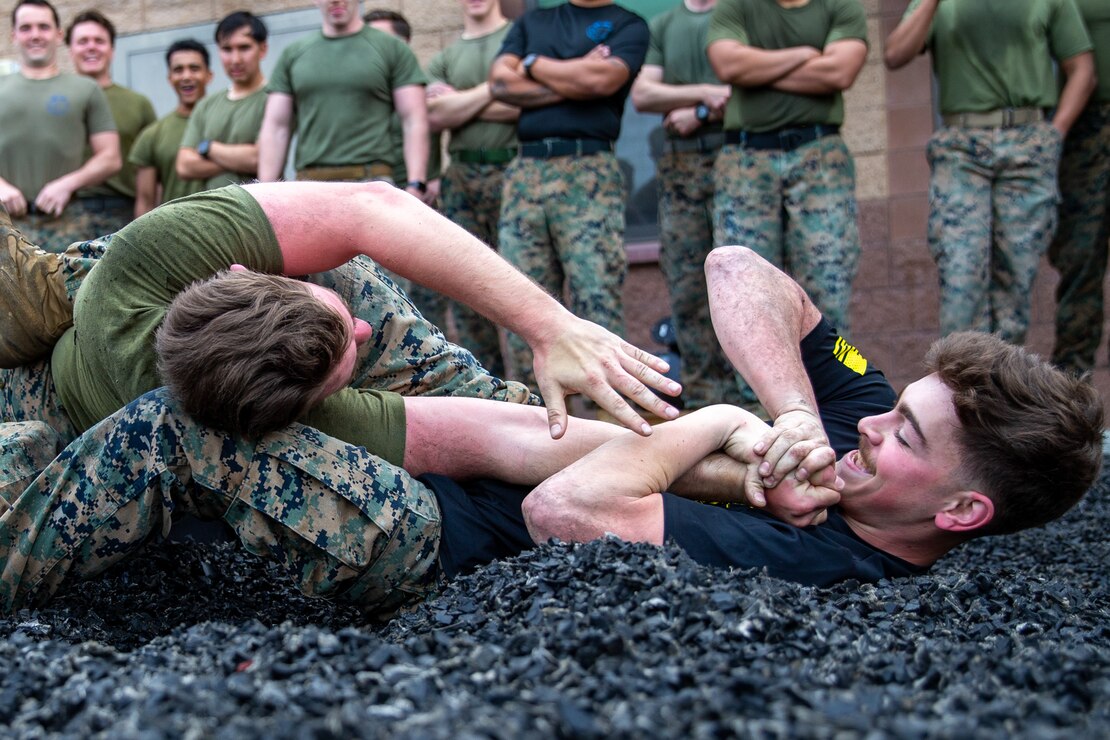 U.S. Marine Corps Cpl. Logan Schultz, a automotive maintenance technician with 1st Air Naval Gunfire Liaison Company, I Marine Expeditionary Force Information Group, right, applies an armbar on U.S. Marine Corps Cpl. Justin Goleniak, a fire support Marine with 1st Air Naval Gunfire Liaison Company, I Marine Expeditionary Force Information Group, during a company-wide ground fighting event at Marine Corps Base Camp Pendleton, California, March 17, 2023. ABC is intended to develop the proficiency of Marines and Sailors in infantry tactics, patrolling, small arms, communications, operations in the Information environment, field craft, call for control, helicopter/tilt-rotor rope suspension techniques and other specialized demanding activities.