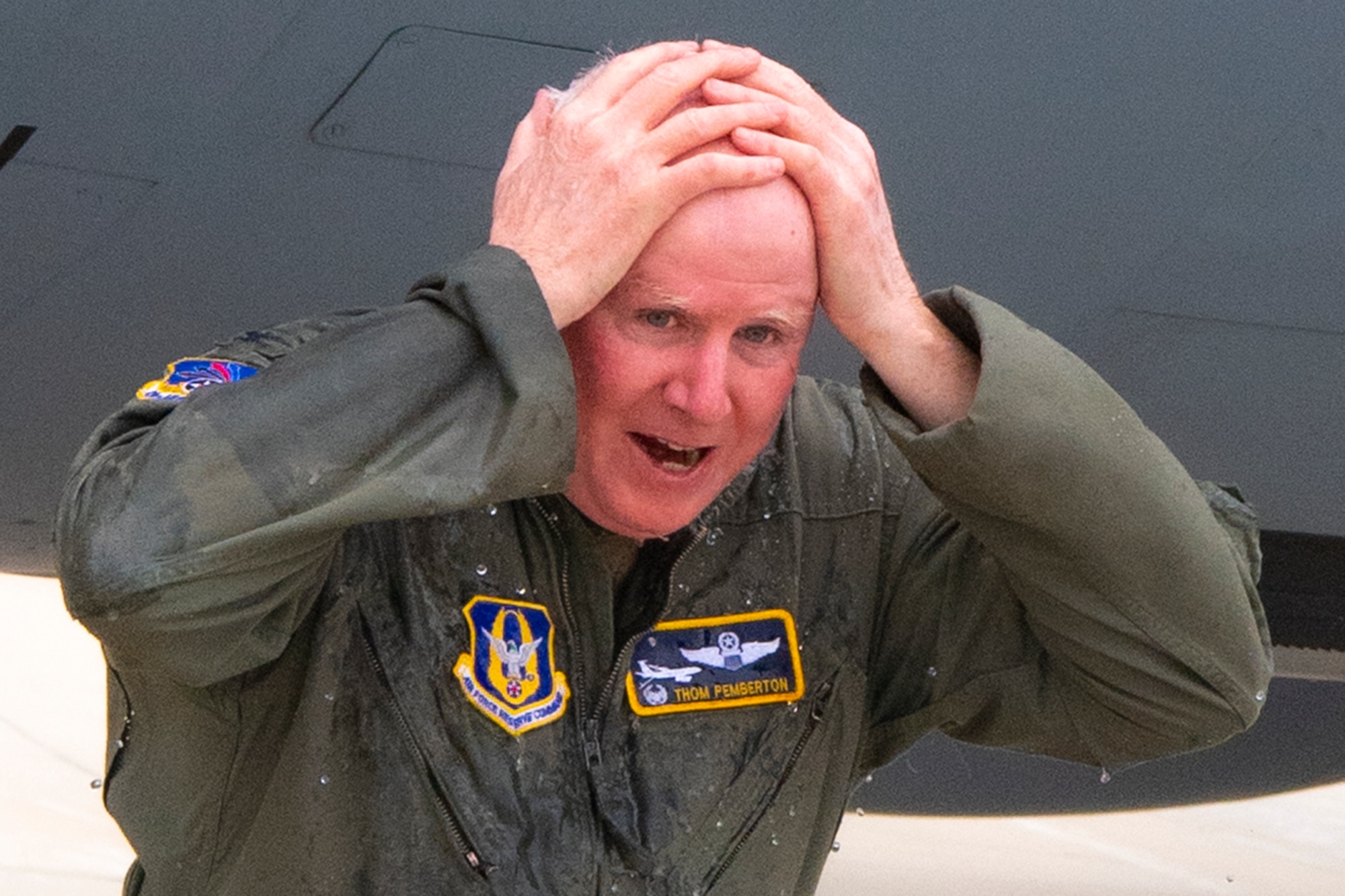 Col. Thom Pemberton, 434th Air Refueling Wing commander, wipes the water off of his head after being drenched following his last flight on March 21,2023. As part of tradition, aircrew are often doused with water following their final flight. (Photo by Tech. Sgt. Jami Lancette)