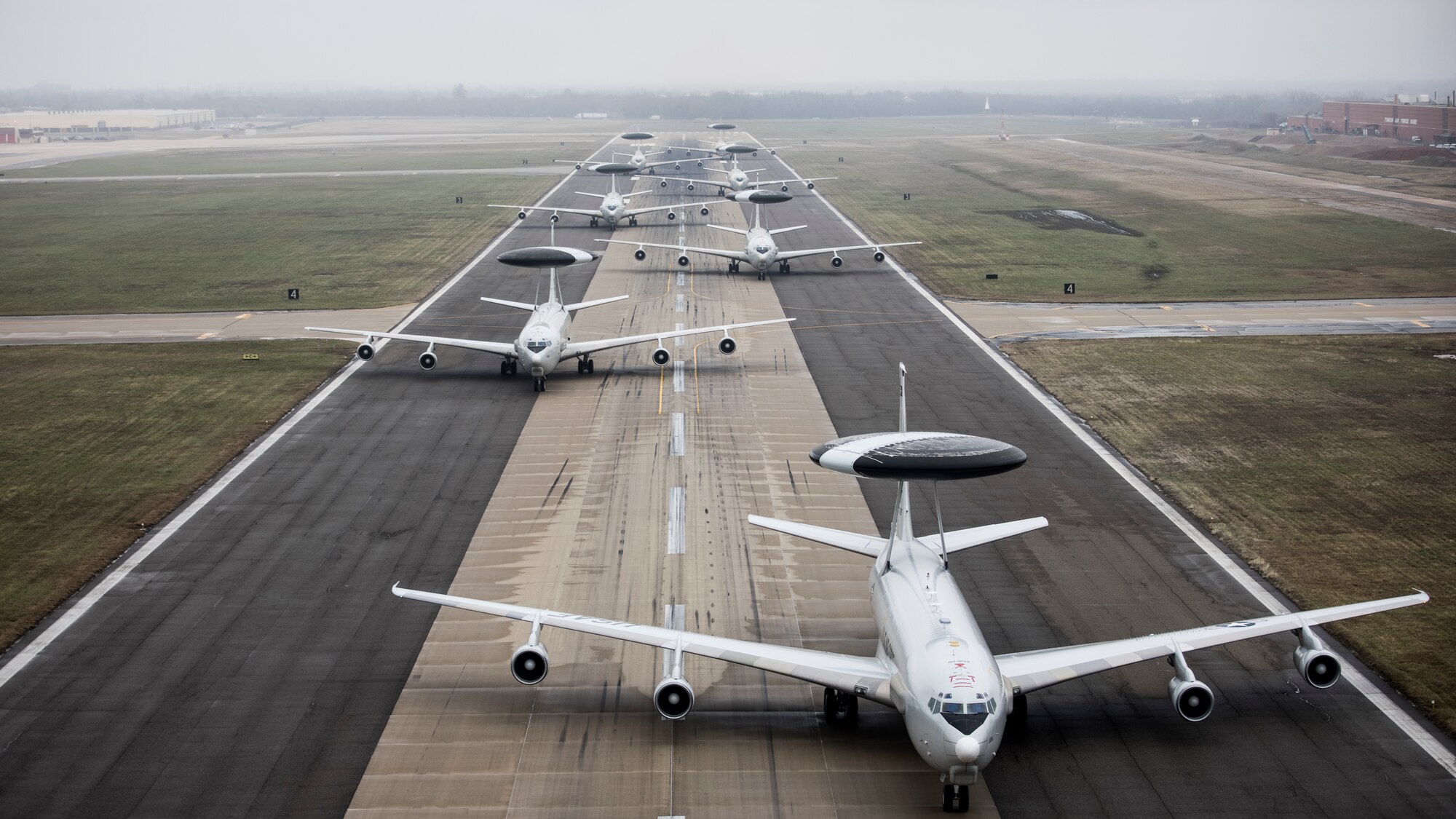 Seven E-3 Sentry aircraft staggered on the runway.