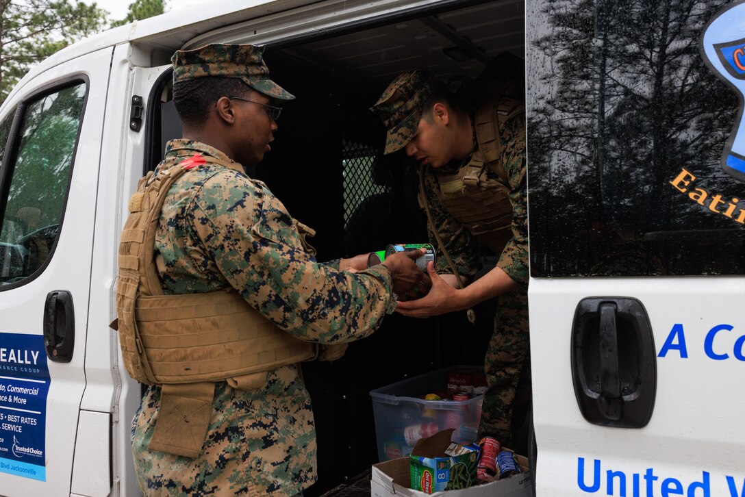 U.S. Marines with 2nd Supply Battalion, 2nd Marine Logistics Group, load a charity van with canned goods during a battalion hike on Camp Lejeune, North Carolina, March 10, 2023. Marines with 2nd Supply Battalion hiked a total of six miles carrying carrying and later donating hundreds of canned goods to a local charity in Jacksonville, North Carolina. (U.S. Marine Corps photo by Lance Cpl. Mary Kohlmann)
