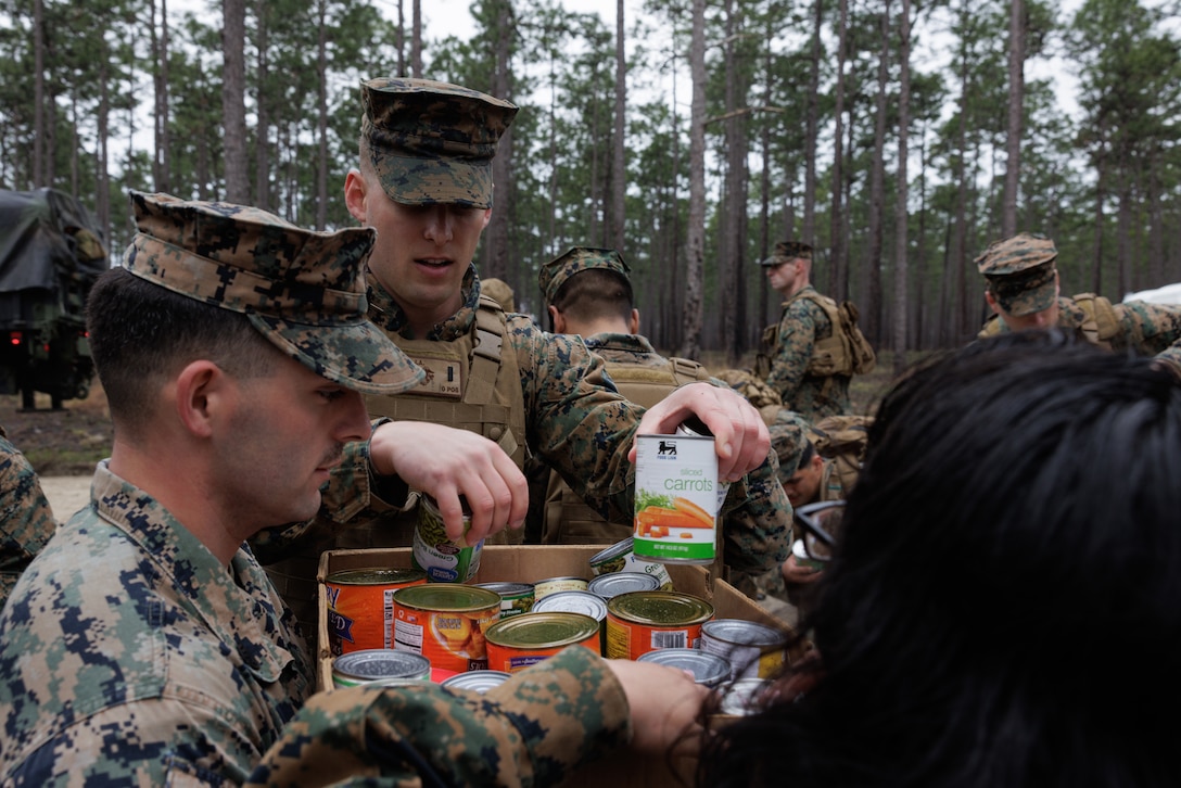 U.S. Marines with 2nd Supply Battalion, 2nd Marine Logistics Group, places canned goods into boxes to be donated to charity on Camp Lejeune, North Carolina, March 10, 2023. Marines with 2nd Supply Battalion hiked a total of six miles carrying and later donating hundreds of canned goods to a local charity in Jacksonville, North Carolina. (U.S. Marine Corps photo by Lance Cpl. Mary Kohlmann)