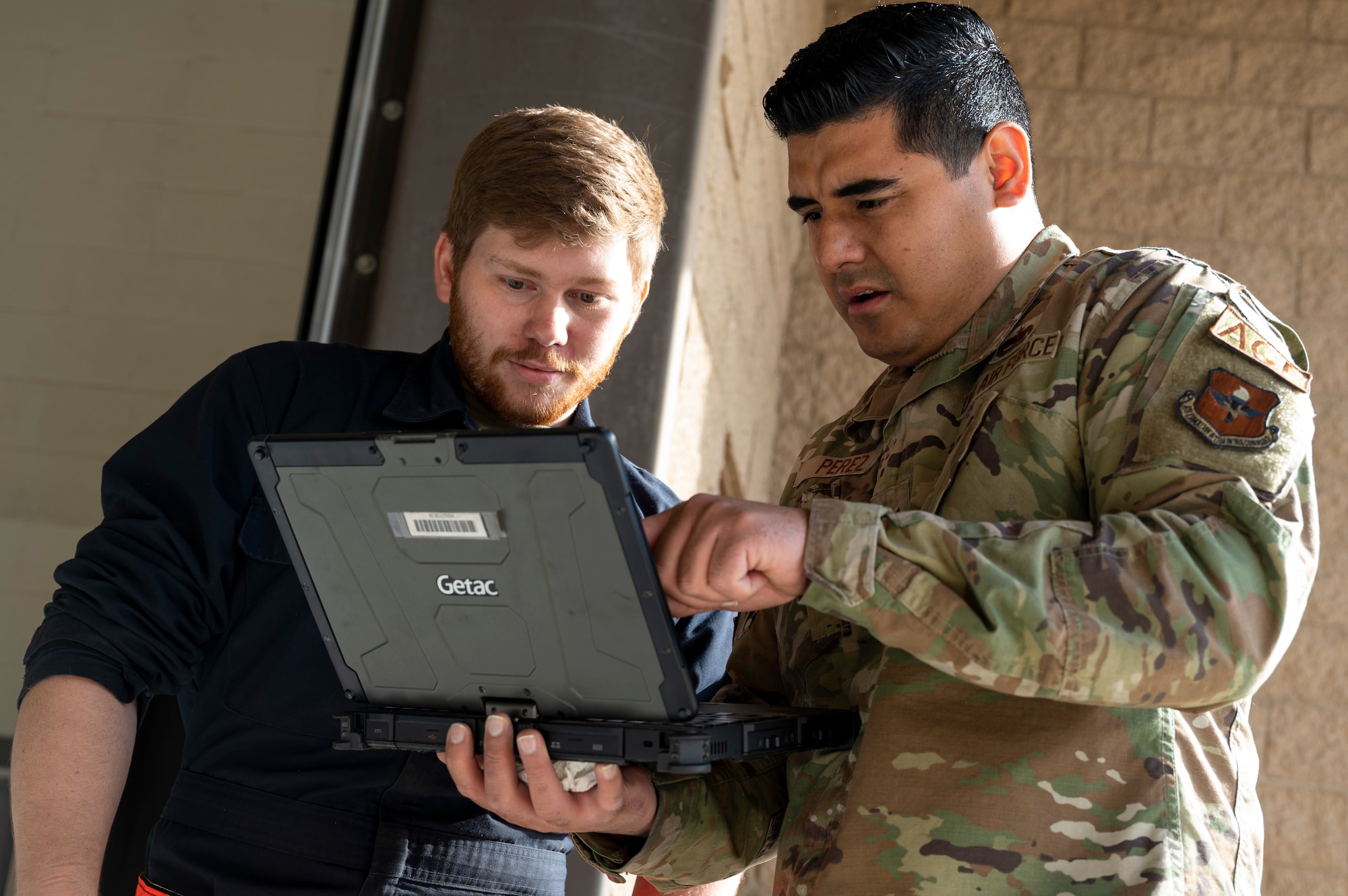 U.S. Air Force Senior Airman Caleb Kubesch, 49th Equipment Maintenance Squadron aerospace ground equipment journeyman, left, and U.S. Air Force Staff Sgt. Andrei Perez, 49th EMS AGE maintenance floor lead, review technical orders at Holloman Air Force Base, New Mexico, March 21, 2023.
