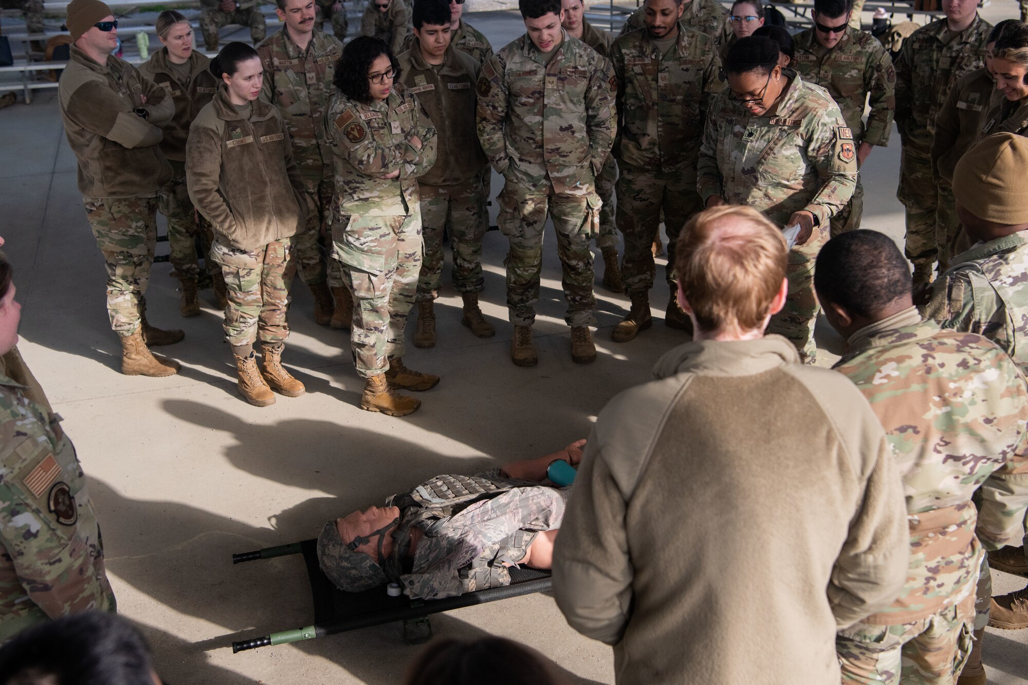 Airmen gather around a dummy to evaluate the care given to the dummy at Maxwell Air Force Base, March 16, 2023. Airmen learned how to make do with what they had on hand and how to use makeshift tools.
