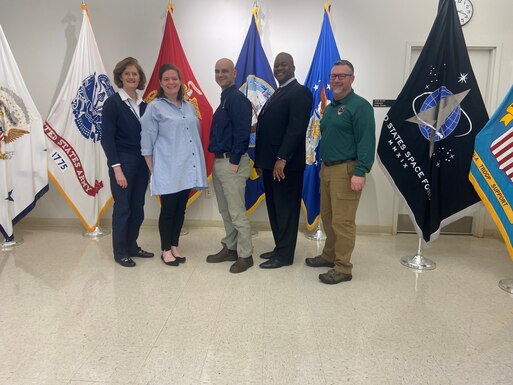 FEMA leadership pose for a photo at the DLA Troop Support Flag Room during a visit to the organization March 6.