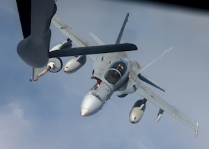 A U.S. Marine Corps F/A-18C Hornet prepares to be refueled by a U.S. Air Force KC-135 Stratotanker from Fairchild Air Force Base over the Pacific, March 9, 2023. Aircrew from the 384th Air Refueling Squadron conducted an air refueling coronet with Marines from the Marine Fighter Attack Squadron 312, demonstrating the critical role mobility forces have in projecting the joint force anywhere, anytime. (U.S. Air Force photo by Staff Sgt. Lawrence Sena)