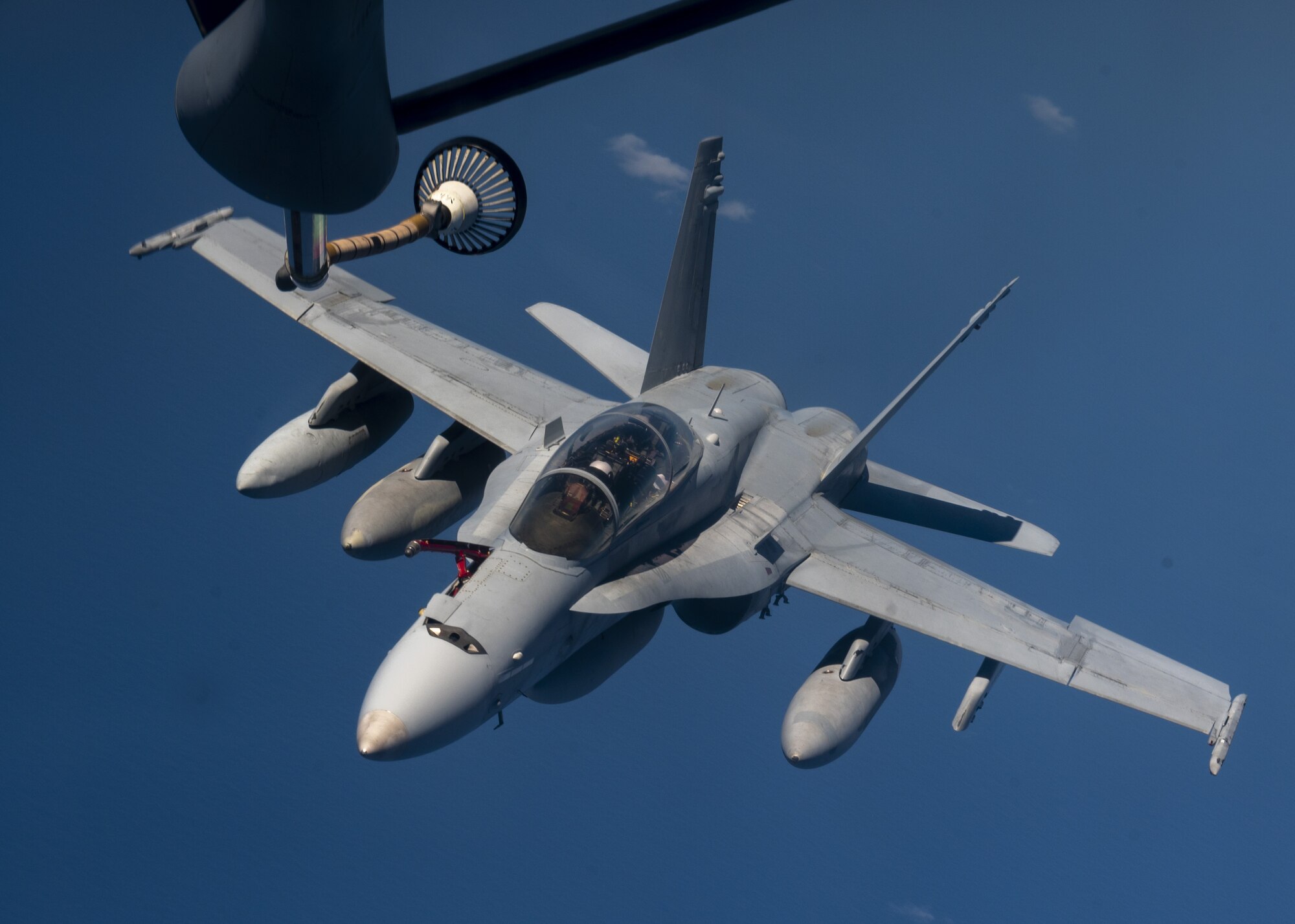 A U.S. Marine Corps F/A-18C Hornet prepares to be refueled by a U.S. Air Force KC-135 Stratotanker from Fairchild Air Force Base over the Pacific, March 9, 2023. Aircrew from the 384th Air Refueling Squadron conducted an air refueling coronet with Marines from the Marine Fighter Attack Squadron 312, demonstrating the critical role mobility forces have in projecting the joint force anywhere, anytime. (U.S. Air Force photo by Staff Sgt. Lawrence Sena)
