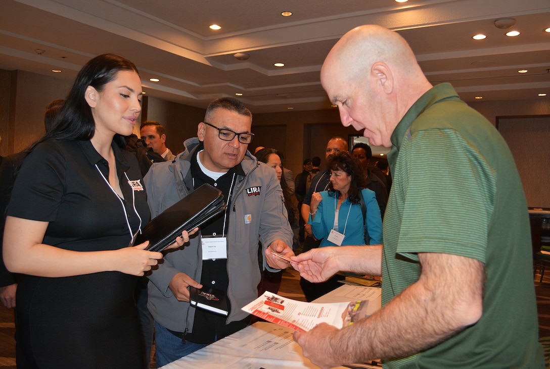 John Stephens, area engineer for the Palmdale Area Office, U.S. Army Corps of Engineers Los Angeles District, right, speaks to Jazmine Lira, left, and Robert Lira, center, both with Lira Electric LLC, about potential opportunities working with the Corps during the March 8 Business Opportunities Open House in Rosemead, California.