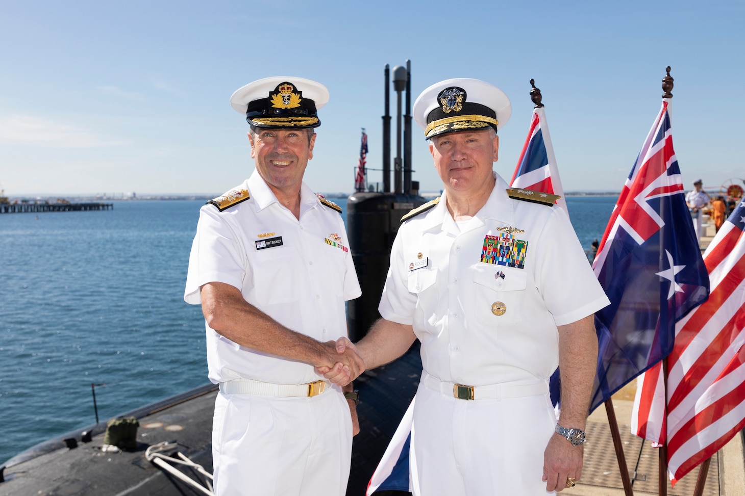 Royal Australian Navy Rear Adm. Matt Buckley, Head of Capability, Nuclear Powered Submarine Task Force and Rear Adm. Rick Seif, commander, Submarine Group 7 pose for a photo before a tour of the Los Angeles-class fast-attack submarine USS Asheville (SSN 758) with Australian political leaders, March 14. Asheville conducted multiple tours for distinguished visitors during a routine port visit to HMAS Stirling, Western Australia to enhance interoperability and communication, and strengthen relationships with the Royal Australian Navy.