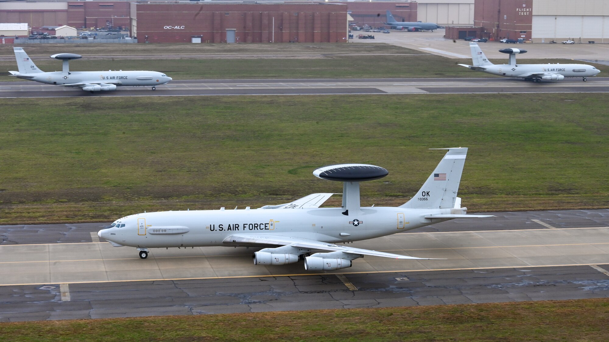 One E-3 Sentry aircraft on taxiway and two 3-E Sentry aircraft on the runway.
