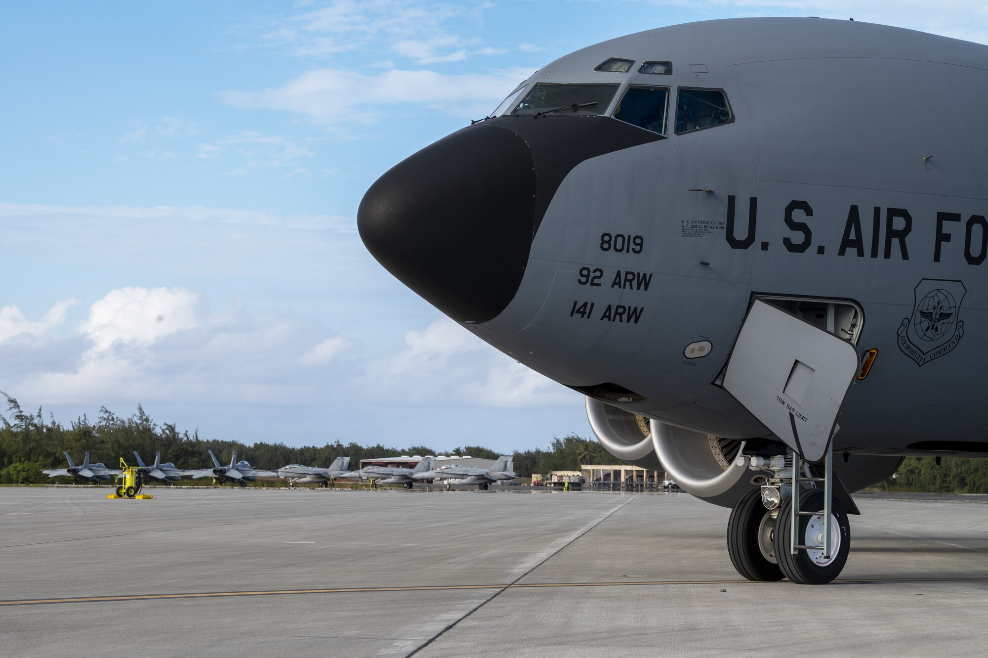 A U.S. Air Force KC-135 Stratotanker and multiple U.S. Marine F/A-18C Hornets are parked on the flightline following an air refueling coronet mission at Wake Island, March 9, 2023. Aircrew from the 384th Air Refueling Squadron conducted an air refueling coronet with Marines from the Marine Fighter Attack Squadron 312, demonstrating the critical role mobility forces have in projecting the joint force anywhere, anytime. (U.S. Air Force photo by Staff Sgt. Lawrence Sena)