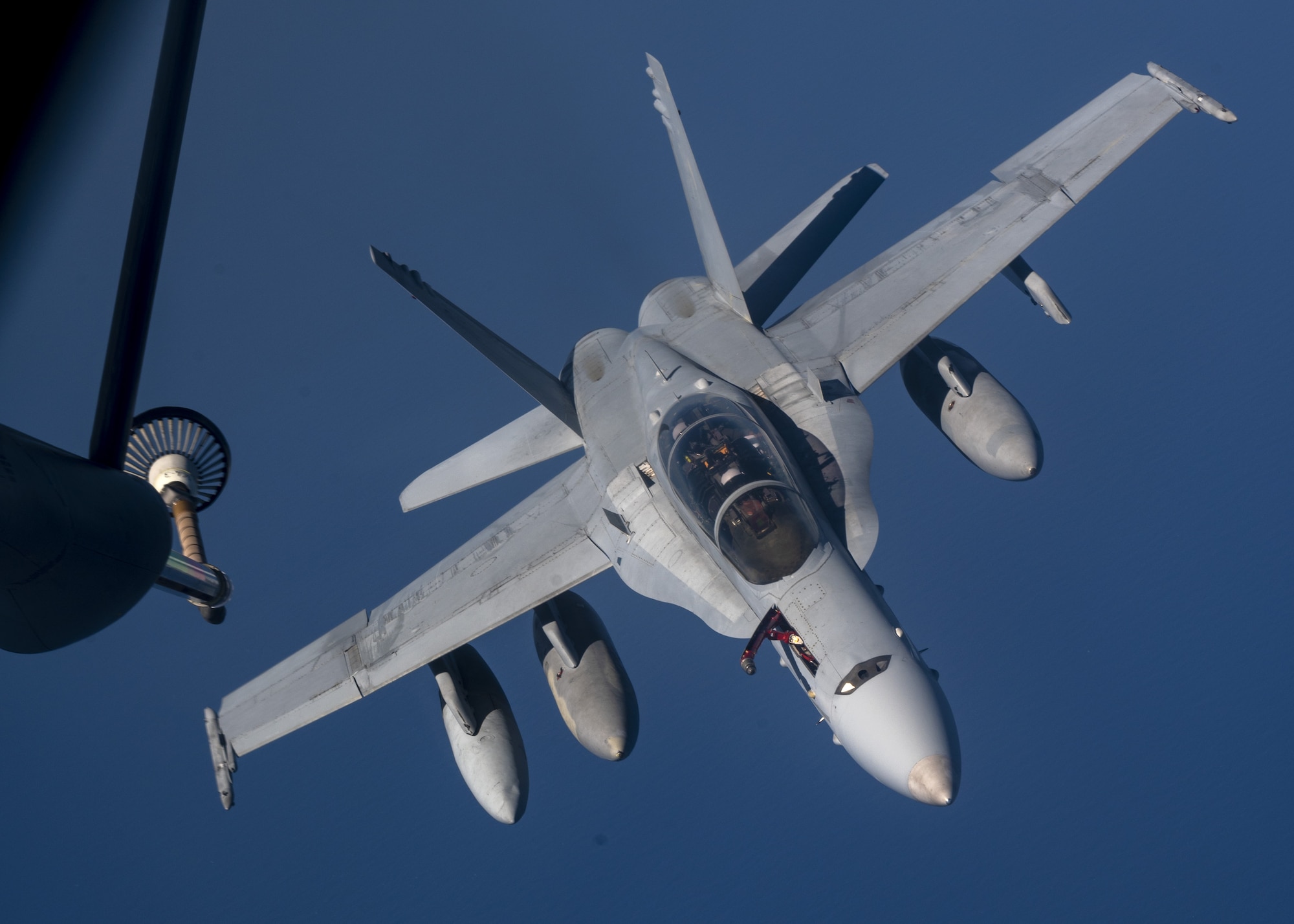 A U.S. Marine Corps F/A-18C Hornet prepares to be refueled by a U.S. Air Force KC-135 Stratotanker from Fairchild Air Force Base over the Pacific, March 9, 2023. Aircrew from the 384th Air Refueling Squadron conducted an air refueling coronet with Marines from the Marine Fighter Attack Squadron 312, demonstrating the critical role mobility forces have in projecting the joint force anywhere, anytime. (U.S. Air Force photo by Staff Sgt. Lawrence Sena)