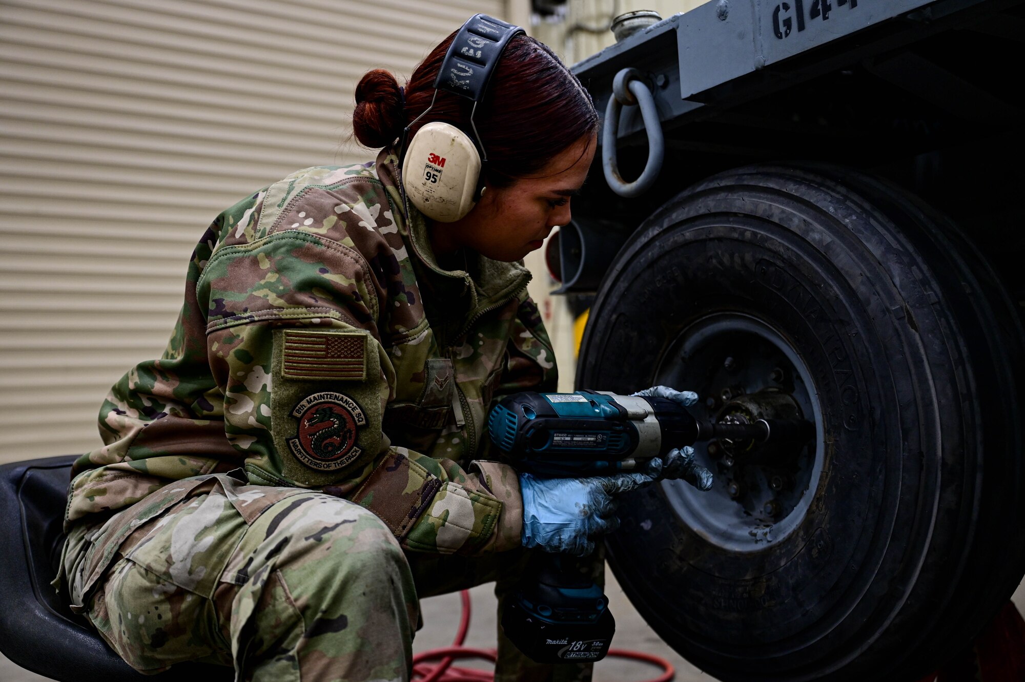 Airman 1st Class Tyra Rosario Diaz, 8th Maintenance Squadron munitions systems equipment maintenance technician, uses an impact wrench to attach lug nuts to a munitions trailer at Kunsan Air Base, Republic of Korea, Mar 15, 2023.