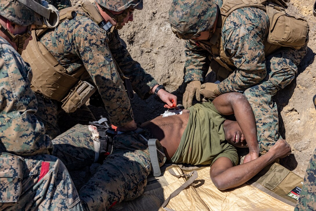 U.S. Marines and Sailors with the 26th Marine Expeditionary Unit (MEU) provide medical aid to a simulated casualty during a mass casualty exercise part of MEU Exercise (MEUEX) III at Marine Corps Auxiliary Landing Field Bogue, North Carolina, March 8, 2023. The exercise focused on providing immediate care to personnel in a simulated combat environment who have sustained severe injuries. (U.S. Marine Corps photo by Lance Cpl. Rafael Brambila-Pelayo)