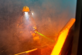 Firefighters simulate putting out a fire using a digital fire training system at NAF Atsugi, Japan.